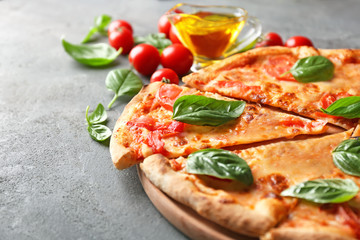 Composition with pizza, oil cherry tomatoes and fresh basil on grey background