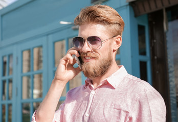 Young hipster man talking on phone outdoors