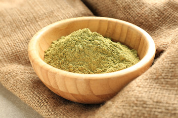 Hemp protein in wooden bowl on sack cloth