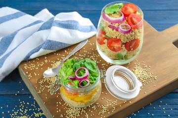 Composition with quinoa and vegetables in glassware on table