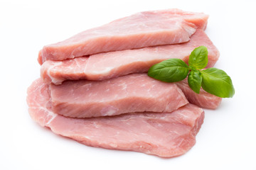Fresh pork fillet with basil on a white background.