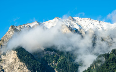 snow covered mountain with mist in the Alps near Maienfeld in Switzerland