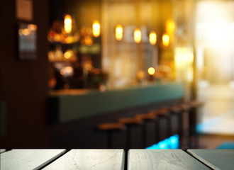 top of wood table with blur light of pub and bar in the dark night