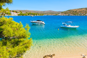 Fototapeta na wymiar Boats on sea and beach with turquoise crystal clear sea water in Rogoznica town, Dalmatia, Croatia