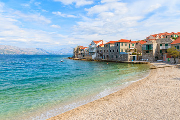 Beach in Postira town with old houses on shore, Brac island, Croatia