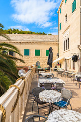 PUCISCA TOWN, CROATIA - SEP 7, 2017: Tables on cafe terrace in Pucisca town, Brac island, Croatia.