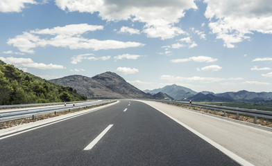 Highway outside the city receding into the highlands.