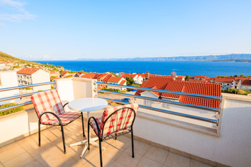 Fototapeta premium BOL TOWN, CROATIA - SEP 9, 2017: Two chairs with table on terrace of holiday apartment in Bol town, Brac island, Croatia. This island has famous port with beautiful old town.