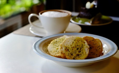 a simple garlic bread served as a snack with warm beverages in a coffee shop in the late morning.