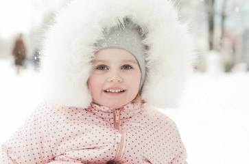 Smiling little girl on sled in winter