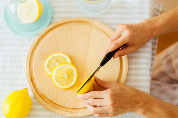 Young woman preparing lemonade in kitchen, closeup, top view