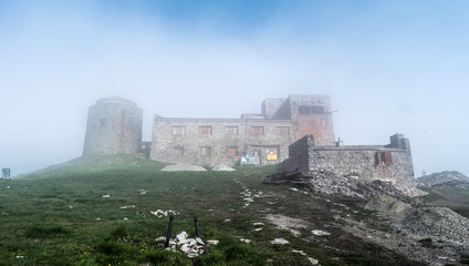 Mist mountain landscape with old abandoned observatory on mount Pip Ivan in Carpathian mountains