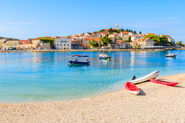 Kayaks and boats on beach in Primosten town, Dalmatia, Croatia - obrazy, fototapety, plakaty