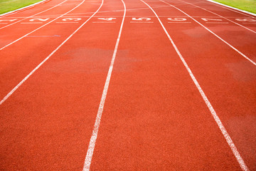 Fototapeta premium Sport, game, competition and exercise concept.red rubber racetracks running lane with number and line in white color. Jogging track, outdoor stadium for running practice and race