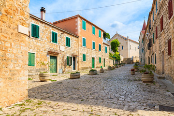 Street with typical stone houses in Postira old town, Brac island, Croatia