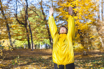 Fototapeta premium attractive elderly woman enjoys the sun in autumn forest