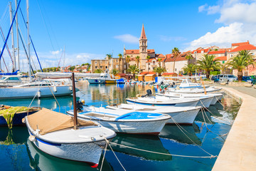 Fishing boats and view of beautiful church in Milna port on sunny summer day, Brac island, Croatia