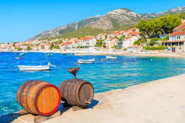 Butts of wine in Bol port with beautiful sea and mountains view, Brac island, Croatia