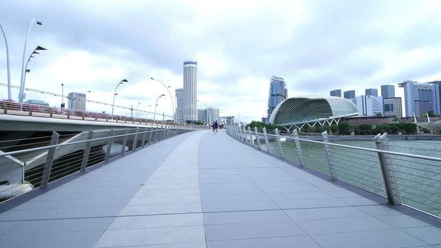 Panning shot of Jubilee Bridge with Singapore skyscraper on the background at daytime