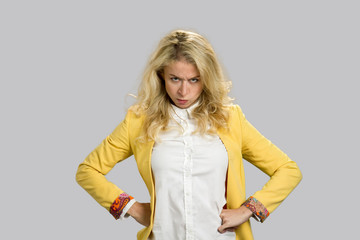 Portrait of dissatisfied young woman. Severe powerful frowning young woman holding hands on hips...