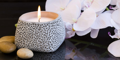 Spa candle setting with orchid and massage stones