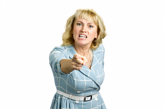 Angry woman screaming and pointing with finger. Pissed off businesswoman pointing with index finger. Irritated mature woman shouting and pointing with index finger on someone, white background.
