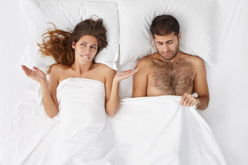 People, health problems, difficulties and crisis concept. Depressed couple have troubles, can`t recieve satisfaction in bed. Man has problem with impotence after stress, expreience erection failure