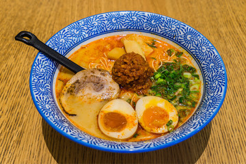 Japanese Tamago spicy Ramen with Cha Shu pork on wooden background