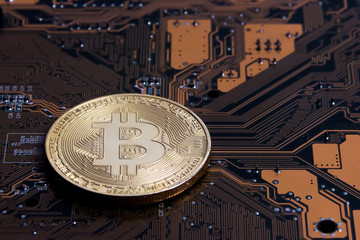 Silver Bitcoin lies on the tracks of the electronic board.