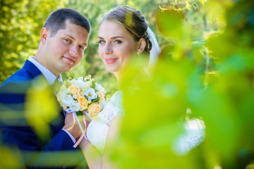 Happy bride and groom after wedding ceremony .Groom is younger than the bride. Wedding couple, newlyweds in a park kissing. Couple newlyweds bride and groom at a wedding in nature green forest