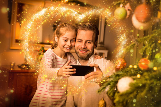 Christmas - father and daughter take 'selfie' photo on phone