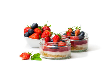 Mini  wild forest berries cheesecake in a glass pots isolated on white background