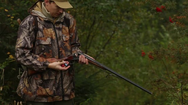 Hunter charges a hunting rifle with cartridges