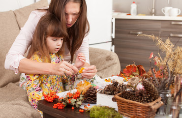 Mother and daughter make dolls from natural materials