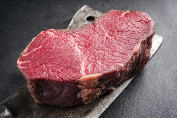 Dry aged raw kobe point steak as close-up on a kitchen cleaver