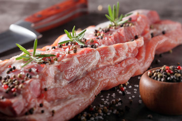 Raw ribs with spices on stone background