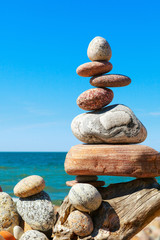 Stones balance on a background of blue sky and sea