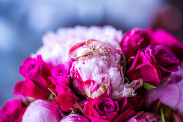 wedding rings on purple and pink bouquet