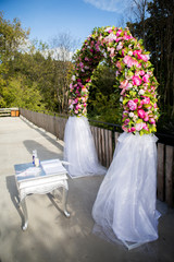 wedding arch decorated with pink and colourful flowers