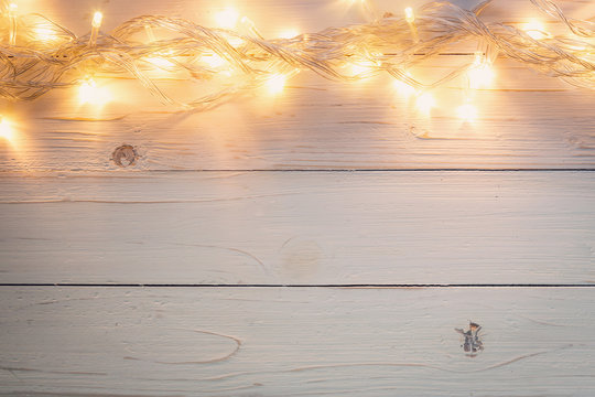 christmas background and lights garland on wood background with space.