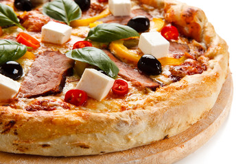 Pizza with ham and feta cheese and vegetables on white background