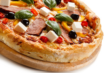 Pizza with ham and feta cheese and vegetables on white background