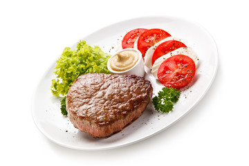 Grilled beef steak with mozzarella and vegetables on white background 