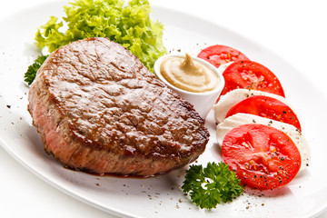 Grilled beef steak with mozzarella and vegetables on white background 