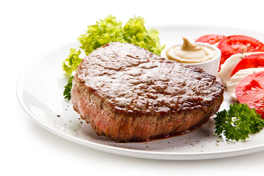 Grilled beef steak with mozzarella and vegetables on white background 