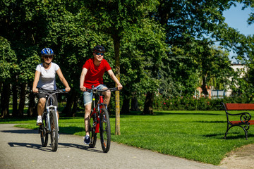 Naklejka premium Healthy lifestyle - people riding bicycles in city park 