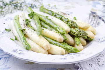 Boiled green and white asparagus as top view on a plate