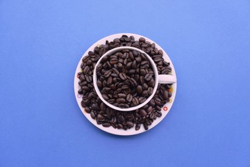 Fototapeta na wymiar Coffee bean in a cup on a blue background.