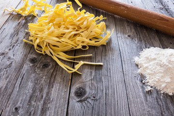 Still life with raw homemade pasta and ingredients for pasta,on rustic wooden background