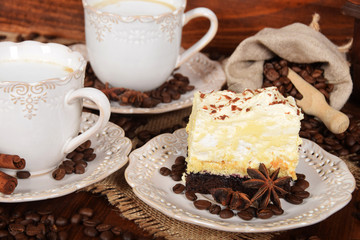 coffee cake with foam and chocolate sprinkles and delicious coffee with milk in retro cups